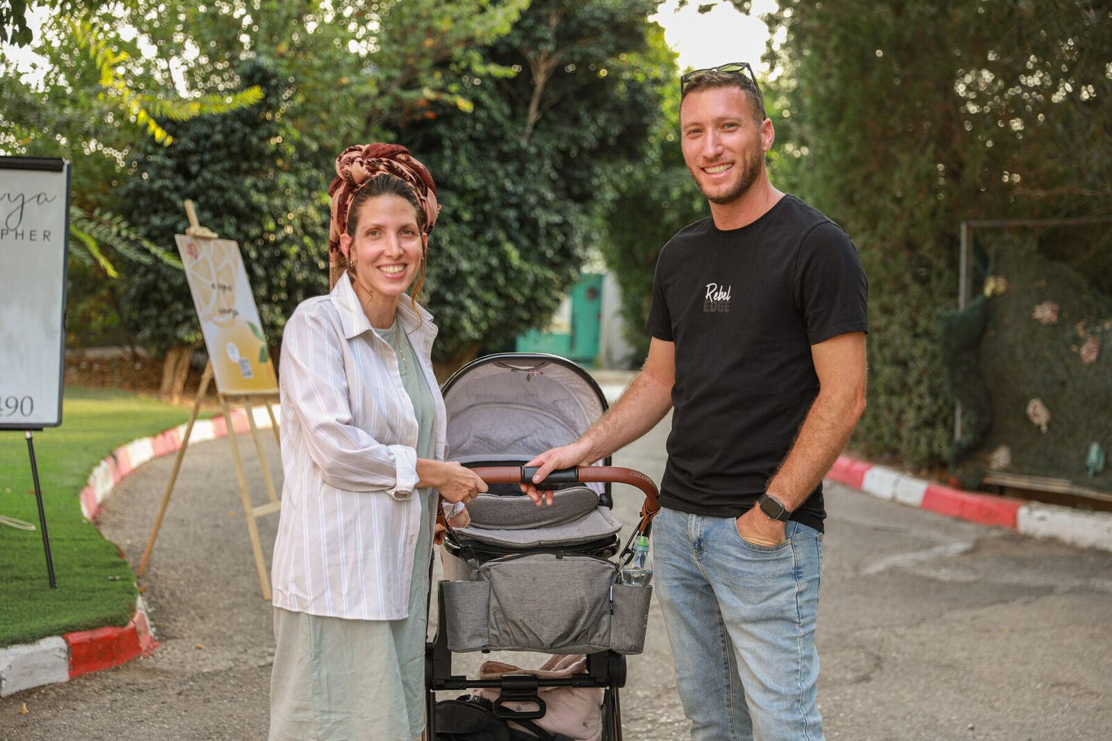 זוג עם עגלת תינוק באירוע משפחתי בחוץ